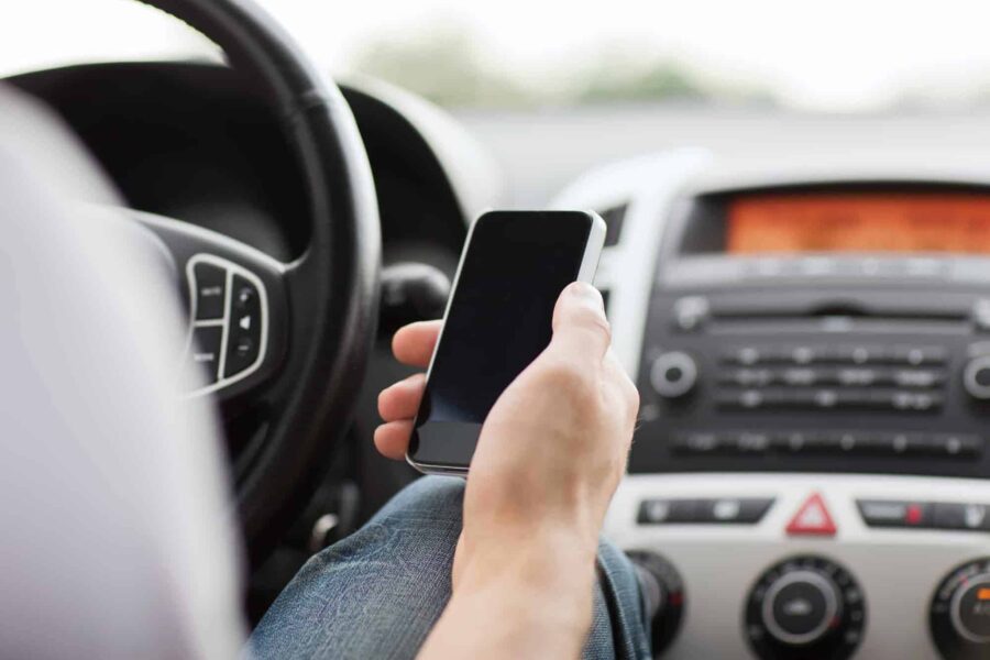 man using phone while driving the car
